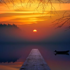 Photo du couché de soleil sur un lac avec de la brume